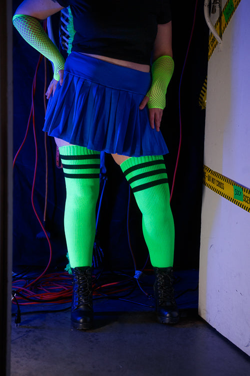 A person wearing Electric Shock thigh highs in neon green with black stripes