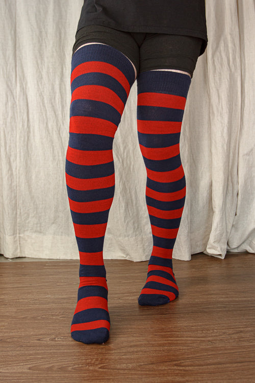 A person wearing XL foot longer extraordinary programming socks in navy and red