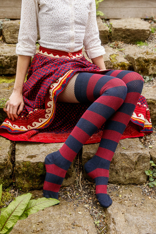 A person wearing striped extraordinary thigh highs in navy and burgundy