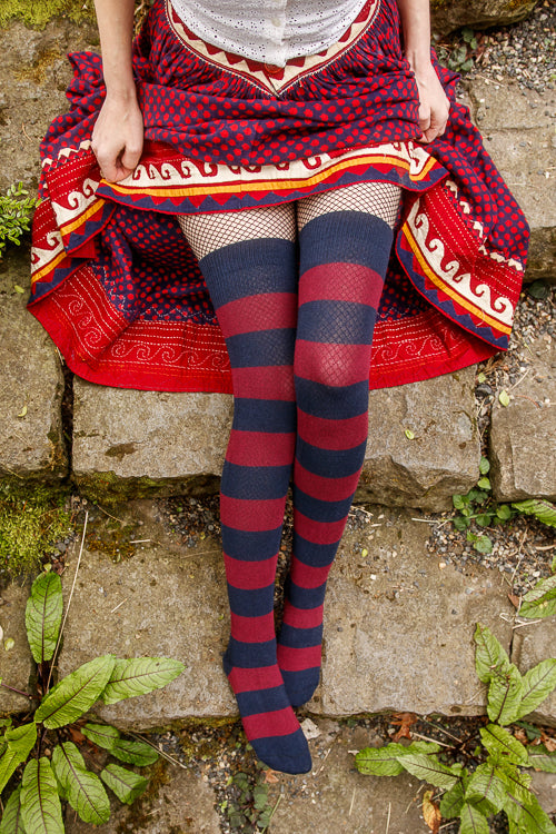 A person wearing striped extraordinary thigh highs in navy and burgundy