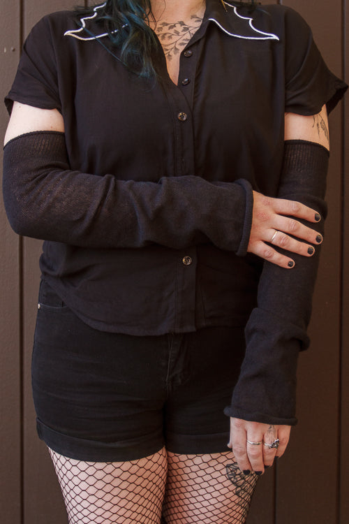 A person wearing longer M sleeves, in black