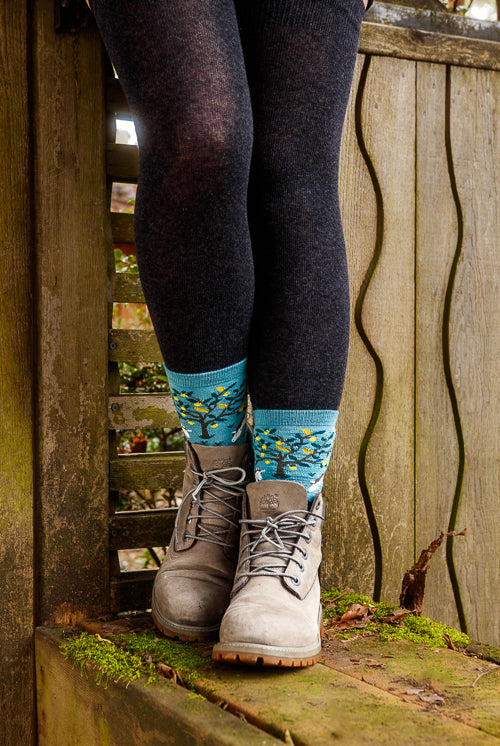 A person wearing unicorn wildlife crew socks in dark teal