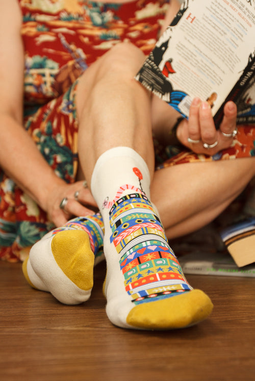 A Person Wearing Out Of Print Bookworm Crew Socks, in cream
