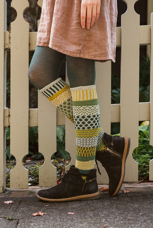 A person wearing fiddlehead knee high socks in various greens