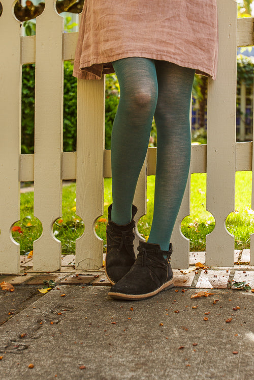 A person wearing Jennifer Wool Tights in pine