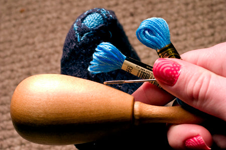 darning supplies and a mended sock