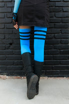 A person wearing Electric Shock thigh highs in neon blue with black stripes