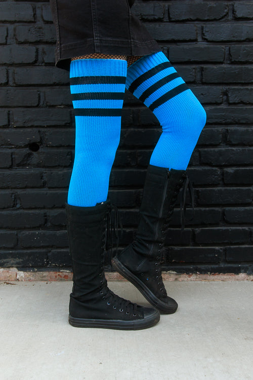 A person wearing Electric Shock thigh highs in neon blue with black stripes