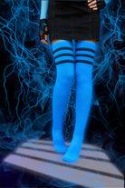 A person wearing Electric Shock thigh highs in neon blue with black stripes