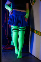 A person wearing Electric Shock thigh highs in neon green with black stripes