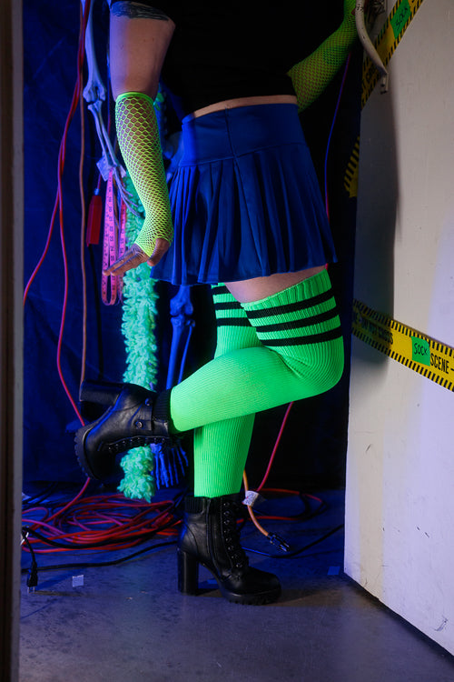 A person wearing Electric Shock thigh highs in neon green with black stripes