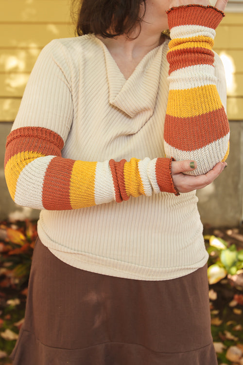 A person wearing Candy Corn striped warmers