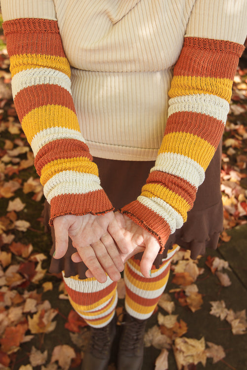 A person wearing Candy Corn striped warmers