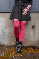 A person wearing Fuchsia M45 thigh high socks with the roll top cuff folded.