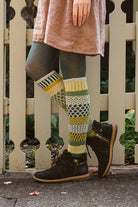 A person wearing fiddlehead knee high socks in various greens