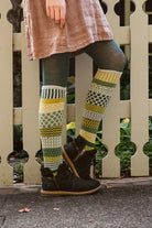 A person wearing fiddlehead knee high socks in various greens